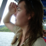Ashley is pictured from her side. She is on a boat and is gazing out across the water.